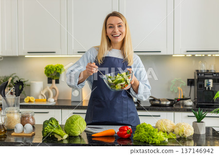 Young woman presenting veggie salad while filming vlog recipe for keto vegetarian healthy nutrition Young woman presenting veggie salad while filming vlog recipe for keto vegetarian healthy nutrition 137146942