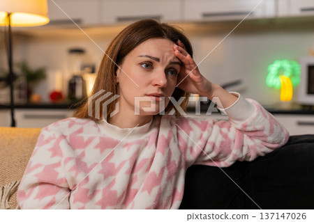 Adult woman depressed anxiety loneliness headache migraine stress at night tired mood unhappy alone Adult woman depressed anxiety loneliness headache migraine stress at night tired mood unhappy alone 137147026