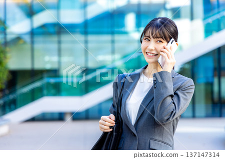 談話在智能手機的女商人 談話在智能手機的女商人 137147314