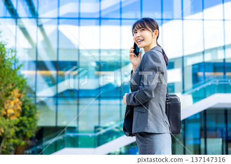 談話在智能手機的女商人 談話在智能手機的女商人 137147316