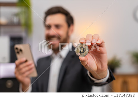 Middle-aged businessman cheers at Bitcoin chart on smartphone shouting wow about investment success Middle-aged businessman cheers at Bitcoin chart on smartphone shouting wow about investment success 137147388