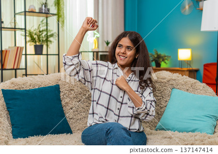 Indian woman celebrates victory fist to chest triumphant shout joyful success gesture proud indoor Indian woman celebrates victory fist to chest triumphant shout joyful success gesture proud indoor 137147414