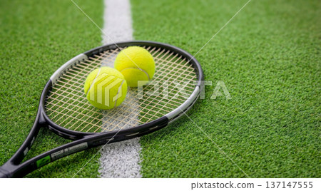 Tennis Racket with Two Balls on Green Court Line, Top View 137147555