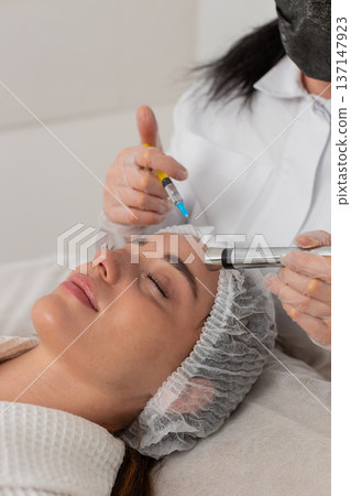 Injection-free mesotherapy or electroporation, beautician makes woman face therapy in clinic salon Injection-free mesotherapy or electroporation, beautician makes woman face therapy in clinic salon 137147923