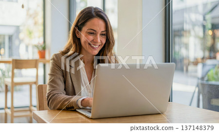 Smiling Businesswoman Working on Laptop in Modern Cafe 137148379
