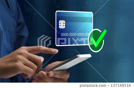 安全的線上支付。一名男子使用智慧型手機在電子商務網站上用信用卡付款。行動支付 137148516