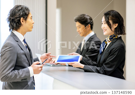 Receptionist guiding customers Receptionist guiding customers 137148590