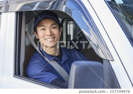 在送貨車駕駛座上,一位面帶微笑的司機 在送貨車駕駛座上,一位面帶微笑的司機 137149478