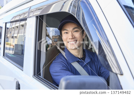 在送貨車駕駛座上，一位面帶微笑的司機 137149482