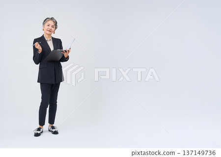 一位資深女商人手持書寫工具和文件 137149736