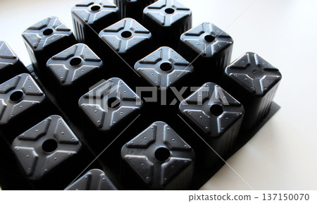 Lower Part Of Black Plastic Cells Of Tray On White Surface Lower Part Of Black Plastic Cells Of Tray On White Surface 137150070