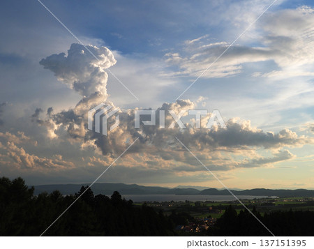 A dragon-shaped cumulonimbus cloud appeared over Lake Inawashiro. It shone in the setting sun and was striking and beautiful against the blue sky. A dragon-shaped cumulonimbus cloud appeared over Lake Inawashiro. It shone in the setting sun and was striking and beautiful against the blue sky. 137151395