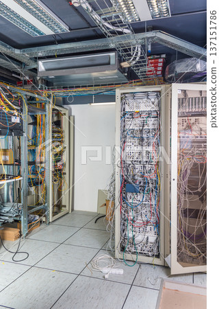 server room rack with tangled network cables creating messy unti 137151786