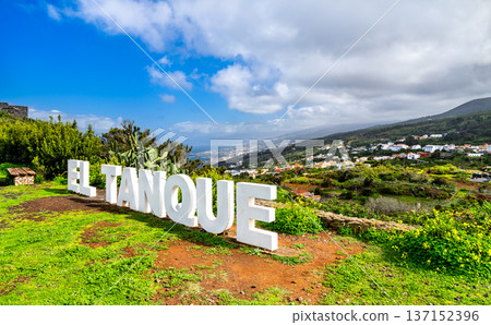 Scenic sunny view of the white El Tanque sign at a lush green viewpoint overlooking the northern coastal towns and ocean in Tenerife, Canary Islands. 137152396