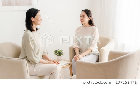 A woman receiving counseling and a smiling counselor 137152471