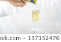 Hand pouring champagne into a glass and sparkling splashes 137152476