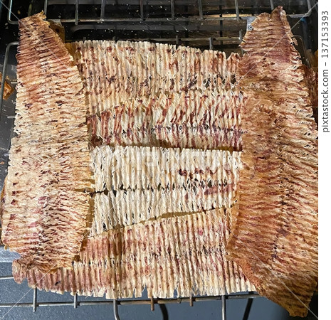 Authentic Thai Grilled Dried Shredded Squid Snack on a Wire Rack Close-up 137153393