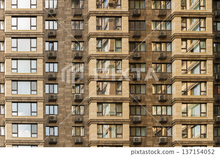 Modern apartment building facade with repeating windows and air conditioning units Modern apartment building facade with repeating windows and air conditioning units 137154052