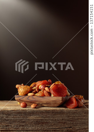 Dried fruits and nuts on a old wooden table. 137154151