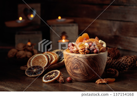 Dried fruits and assorted nuts on a wooden table. 137154168