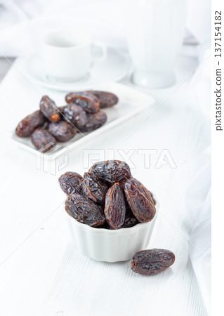 Dried medjool dates on a white table. Dried medjool dates on a white table. 137154182
