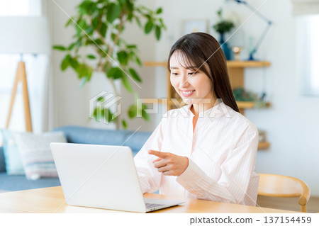 在客廳裡操作個人電腦的女人 137154459