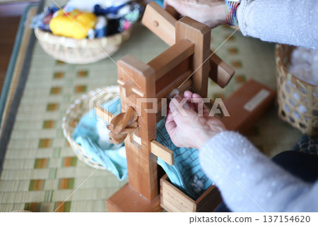 一名婦女正在使用軋棉機 一名婦女正在使用軋棉機 137154620