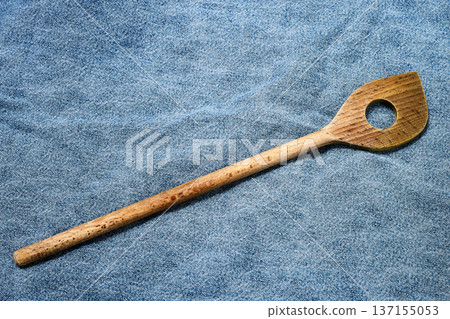 heavily worn wooden spatula against a background of denim jeans heavily worn wooden spatula against a background of denim jeans 137155053