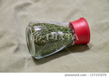 small jar of parsley in a clear glass container small jar of parsley in a clear glass container 137155079