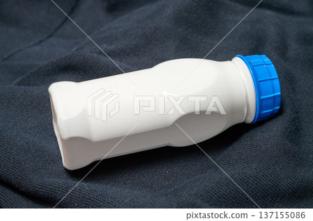 Small white plastic bottle with a blue cap Small white plastic bottle with a blue cap 137155086