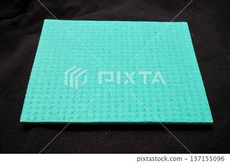 A green micro-fiber sponge on a black background 137155096