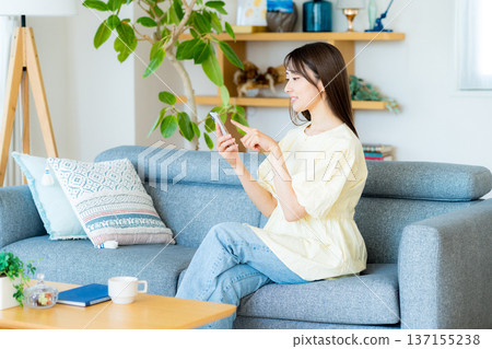 A woman who operates a smartphone in the room A woman who operates a smartphone in the room 137155238