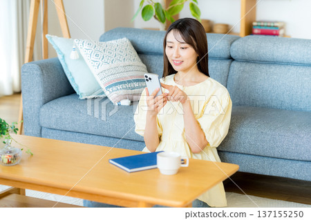 A woman who operates a smartphone in the room A woman who operates a smartphone in the room 137155250