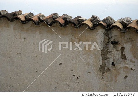 plastered stone wall topped with tiles on top plastered stone wall topped with tiles on top 137155578
