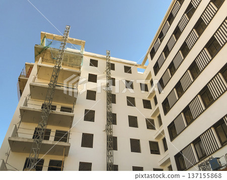 residential building under construction, with scaffolding mounted on the facade. residential building under construction, with scaffolding mounted on the facade. 137155868