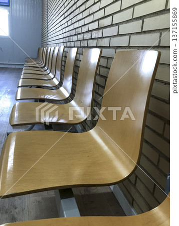 wooden seats illuminated by the window in the background in a hospital waiting room wooden seats illuminated by the window in the background in a hospital waiting room 137155869