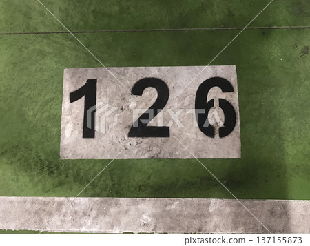number painted in white on a green background on the floor of a subway parking garage number painted in white on a green background on the floor of a subway parking garage 137155873