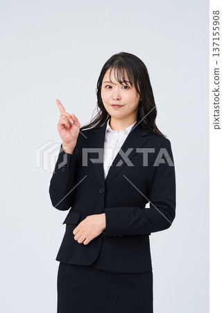A young businesswoman posing with her index finger up A young businesswoman posing with her index finger up 137155908