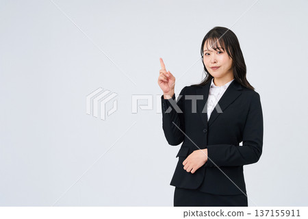 A young businesswoman posing with her index finger up A young businesswoman posing with her index finger up 137155911