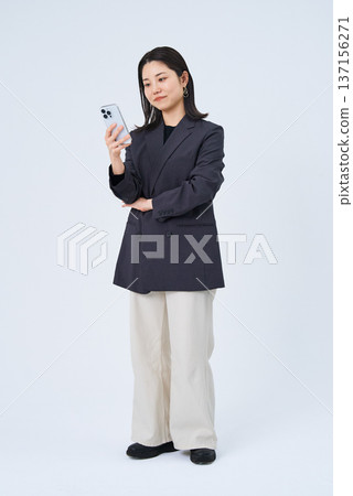 Young business woman operating a smartphone Young business woman operating a smartphone 137156271