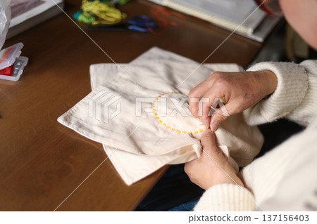 A woman embroidering by hand 137156403