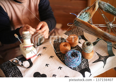 Woman making a ball of yarn Woman making a ball of yarn 137156407