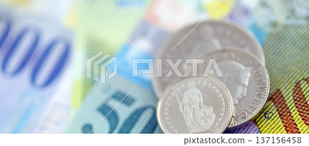 Currency of Switzerland. Banknotes and Swiss franc coins on them. Financial topics in Swiss banking concept. Currency of Switzerland. Banknotes and Swiss franc coins on them. Financial topics in Swiss banking concept. 137156458