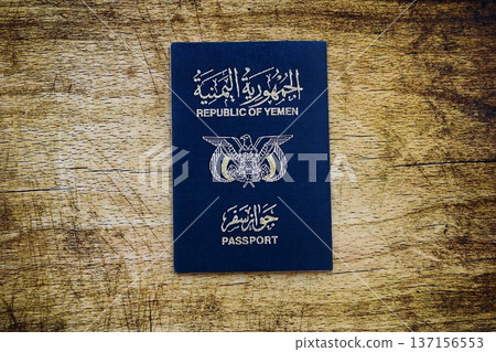 Yemeni passport on table close up. Official identification document book for citizens of Yemen. Concept of travel and tourism Yemeni passport on table close up. Official identification document book for citizens of Yemen. Concept of travel and tourism 137156553