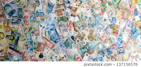 Different banknotes from many various currencies of the whole world. Big bunch of money bills on table close up 137156576
