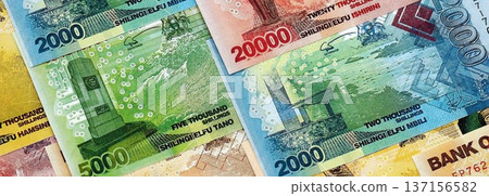 Ugandan shilling paper banknotes pile on table. Uganda UGX currency money bills in big amount. Concept of economics, taxation and banking in Uganda 137156582