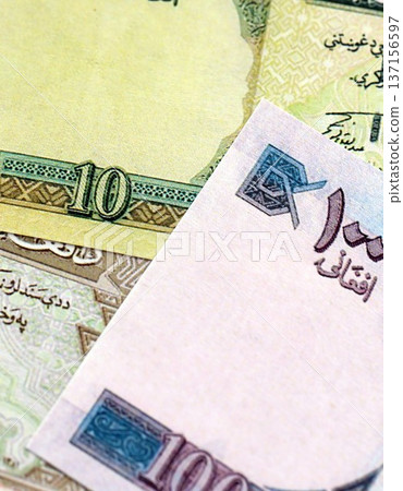 Afghan afghani paper banknotes pile on table. Afghanistan AFN currency money bills in big amount. Concept of economics, taxation and banking in Afghanistan Afghan afghani paper banknotes pile on table. Afghanistan AFN currency money bills in big amount. Concept of economics, taxation and banking in Afghanistan 137156597