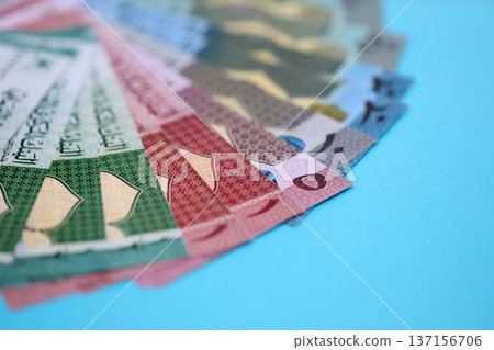 Omani rial paper banknotes fan on blue table. Oman OMR currency money bills in big amount. Concept of economics, taxation and banking in Oman Omani rial paper banknotes fan on blue table. Oman OMR currency money bills in big amount. Concept of economics, taxation and banking in Oman 137156706