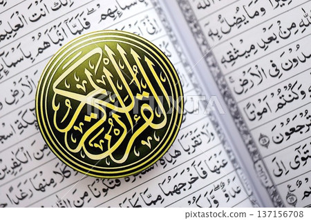 Sign with Al Quran inscription on Muslim holy book in mosque. Details of arabic calligraphy on sticker. Concept of Islam religion and praying in arabic countries Sign with Al Quran inscription on Muslim holy book in mosque. Details of arabic calligraphy on sticker. Concept of Islam religion and praying in arabic countries 137156708