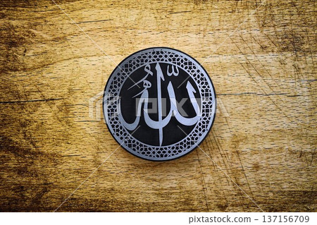 Sign with Islam inscription on table in mosque. Details of arabic calligraphy on paper sticker. Concept of Islam religion and praying in arabic countries 137156709
